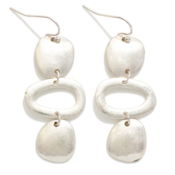 Hammered Geometric Drop Earrings featuring a linear stack of organic shaped discs and an open oval link in a worn metal finish. The artisan inspired texture gives these a collected, boho feel with plenty of movement. Fishhook wires keep them lightweight and comfortable. A statement earring that pairs effortlessly with denim, linen, and flowy dresses for an easy everyday look.