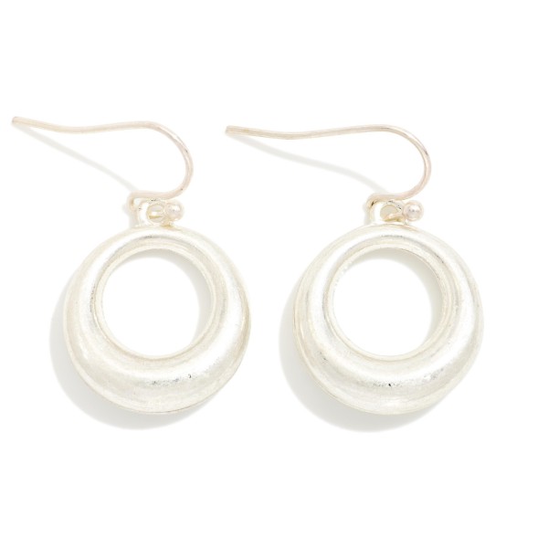 Organic Circle Drop Earrings with a sculpted open ring in a soft brushed finish, hanging from simple fishhook wires. The smooth, rounded shape feels modern and effortless for everyday wear. Lightweight enough for all day comfort. A versatile metal earring at an easy price point that pairs with any outfit and sells well as an impulse purchase near the register.