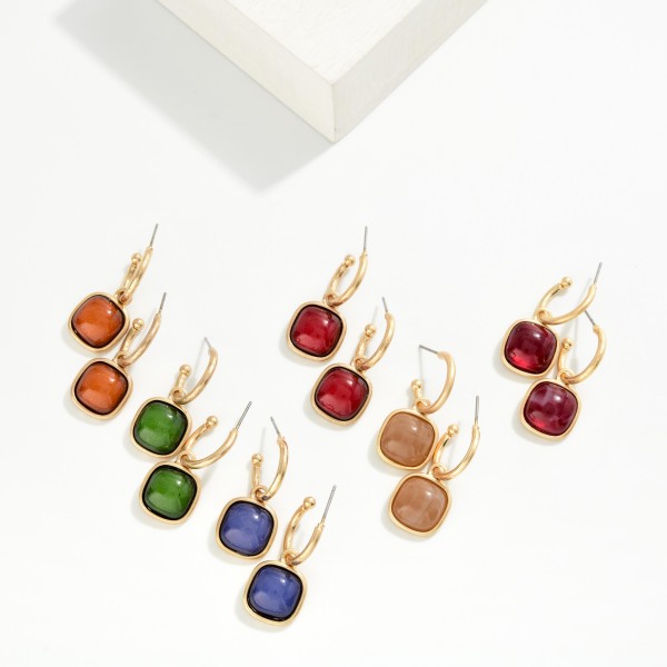 Cushion Stone Hoop Charm Earrings with a framed square cabochon stone that dangles from a polished open hoop. The bold stone and clean metal pairing makes these an easy statement for holiday parties, date nights, and dressing up everyday outfits. Lightweight post backs for comfortable wear. Offered in several stone options, they're a natural upsell alongside the coordinating square stone necklaces and bracelets.