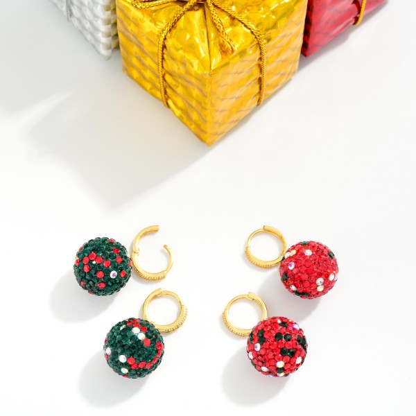 Rhinestone Ornament Ball Huggie Drop Earrings with sparkling pave crystal spheres that look just like a glittering holiday ornament, suspended from a rhinestone accented huggie hoop. Full coverage stones catch light from every angle, and the snug huggie closure keeps them secure and comfortable through parties and family gatherings. A festive pick for Christmas parties, ugly sweater nights, and holiday photos. Bright, giftable, and eye catching on a display, these sell quickly all season long.