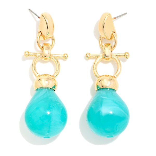 Toggle Drop Earrings pairing a polished metal T bar and ring detail with a glossy marbled resin teardrop. The mix of hardware inspired metal and organic stone look gives a modern, collected feel that dresses up denim and sweaters as easily as evening wear. Lightweight resin keeps them comfortable for hours on post backs. A fresh take on the toggle trend at an impulse friendly price, these are a smart add for boutique earring walls.