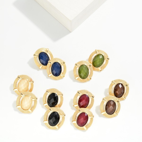 Oval Stone Statement Stud Earrings featuring a faceted oval cabochon set in a textured round metal frame with notched detailing. The decorative border adds vintage charm while the stone delivers rich, polished shine. Lightweight post backs make them comfortable from morning meetings through evening plans. Framed stone studs are a standout fall look and an easy upsell for customers building a curated earring wardrobe.