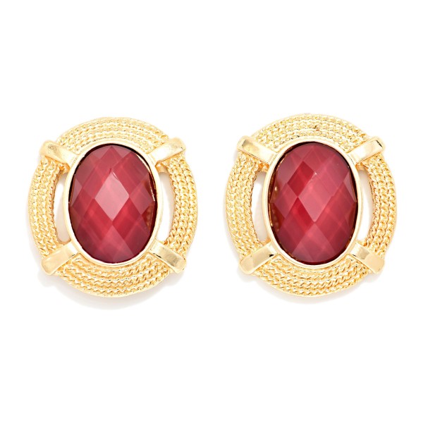 Oval Stone Statement Stud Earrings featuring a faceted oval cabochon set in a textured round metal frame with notched detailing. The decorative border adds vintage charm while the stone delivers rich, polished shine. Lightweight post backs make them comfortable from morning meetings through evening plans. Framed stone studs are a standout fall look and an easy upsell for customers building a curated earring wardrobe.