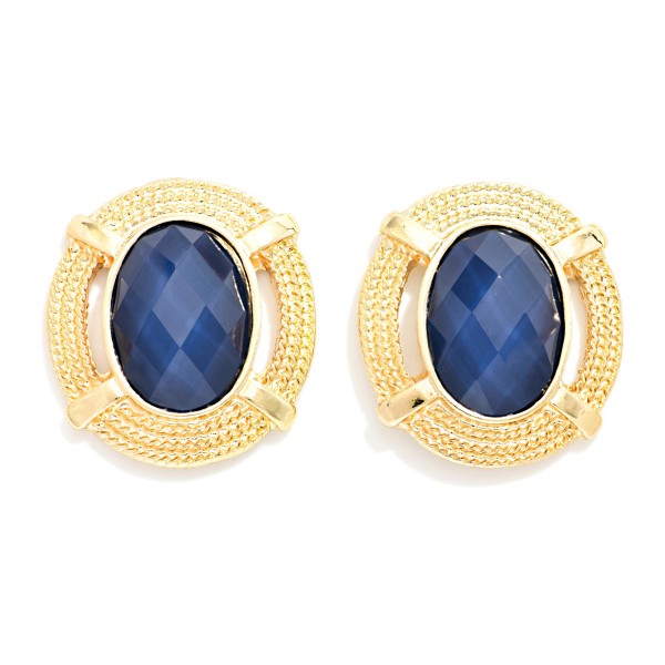 Oval Stone Statement Stud Earrings featuring a faceted oval cabochon set in a textured round metal frame with notched detailing. The decorative border adds vintage charm while the stone delivers rich, polished shine. Lightweight post backs make them comfortable from morning meetings through evening plans. Framed stone studs are a standout fall look and an easy upsell for customers building a curated earring wardrobe.