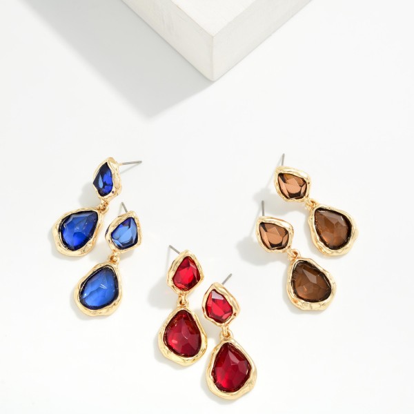 Double Glass Stone Drop Earrings pairing a smaller organic stone with a larger teardrop, each set in a polished bezel. The irregular faceting gives a soft, vintage glow that flatters every skin tone. Wear them to holiday parties, weddings, and dinners out. A gem inspired statement that adds sparkle to any outfit and sells quickly as a gift.