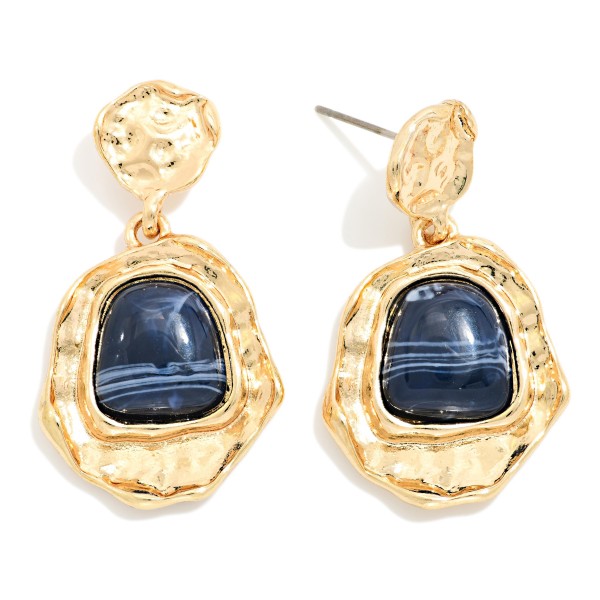 Hammered Frame Stone Drop Earrings with organic, textured settings surrounding a glossy marbled stone. The irregular shapes give them an artisan, vintage inspired feel that pairs well with fall knits and holiday dresses. Post backs keep them comfortable and secure. Bold yet wearable, these statement earrings are an easy upsell for customers shopping for something special.