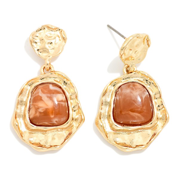 Hammered Frame Stone Drop Earrings with organic, textured settings surrounding a glossy marbled stone. The irregular shapes give them an artisan, vintage inspired feel that pairs well with fall knits and holiday dresses. Post backs keep them comfortable and secure. Bold yet wearable, these statement earrings are an easy upsell for customers shopping for something special.
