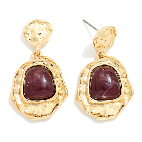 Hammered Frame Stone Drop Earrings with organic, textured settings surrounding a glossy marbled stone. The irregular shapes give them an artisan, vintage inspired feel that pairs well with fall knits and holiday dresses. Post backs keep them comfortable and secure. Bold yet wearable, these statement earrings are an easy upsell for customers shopping for something special.