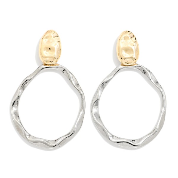 Two Tone Hammered Hoop Drop Earrings with an organic, wavy hoop suspended from a textured oval post. The mixed metal finish makes them easy to pair with any jewelry already in a customer's collection. Light enough for all day wear and bold enough to finish a simple outfit. A modern, versatile statement style that sells across age groups and seasons.