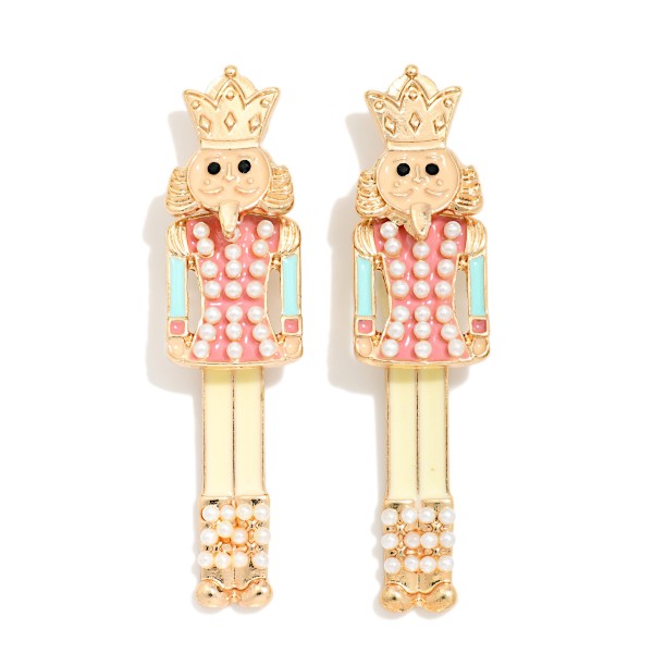Nutcracker Drop Earrings with a crowned soldier silhouette covered in sparkling rhinestones over a polished metal base. The classic holiday figure hangs from comfortable post backs and stays light on the ear. A festive pick for ballet season, holiday parties, recitals, and Christmas photos. Timeless holiday characters like this sell year after year, making it an easy addition to any seasonal jewelry display.