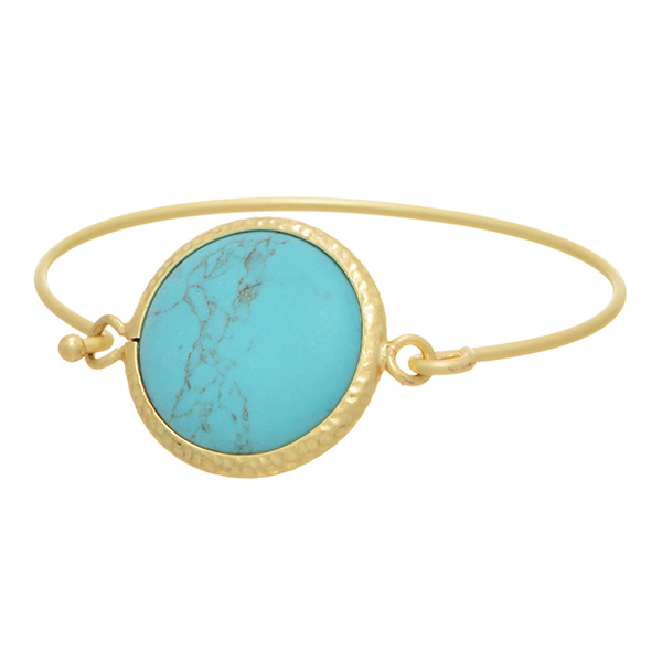 Matte gold tone bangle bracelet featuring a round turquoise stone focal with front latch closure.
