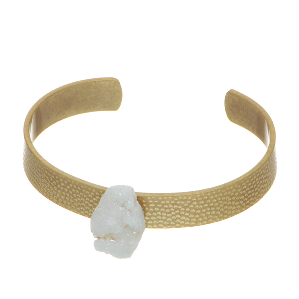 Worn gold tone cuff bracelet featuring textured metal with a white druzy quartz stone focal.