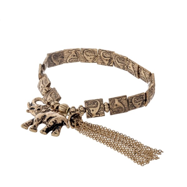 Burnished gold tone stretch bracelet with a stamped elephant design and an elephant charm. 