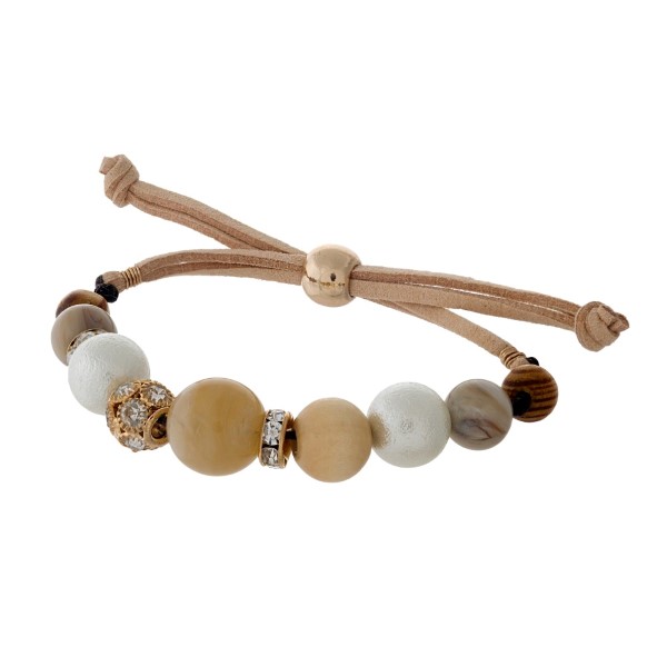 Adjustable tan cord bracelet with wooden and ivory beads. 