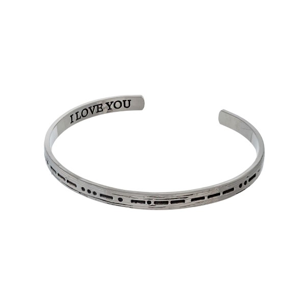 Silver tone cuff bracelet stamped on the outside with morse code and "I love you' on the inside. 