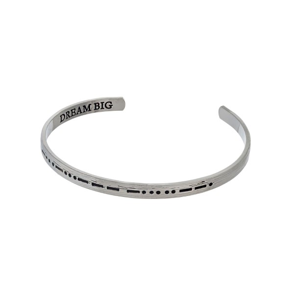 Silver tone cuff bracelet stamped on the outside with morse code and "dream big' on the inside. 