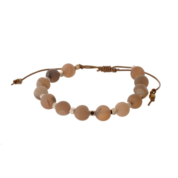 Brown cord adjustable bracelet with peach druzy and gold beads. Handmade in the USA.