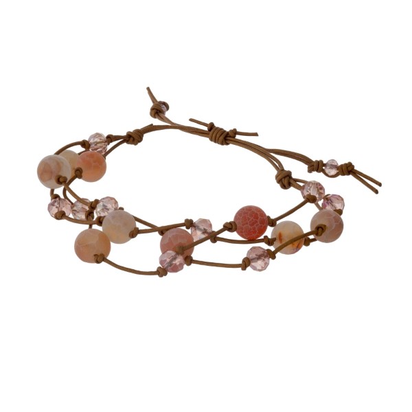 Brown cord adjustable bracelet with two rows of peach and iridescent beads. Handmade in the USA. 
