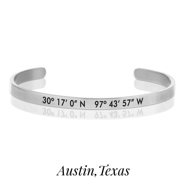 Silver tone cuff bracelet stamped with the coordinates of Austin, Texas. 