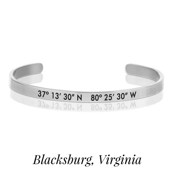 Silver tone cuff bracelet stamped with the coordinates of Blacksburg, Virginia. 