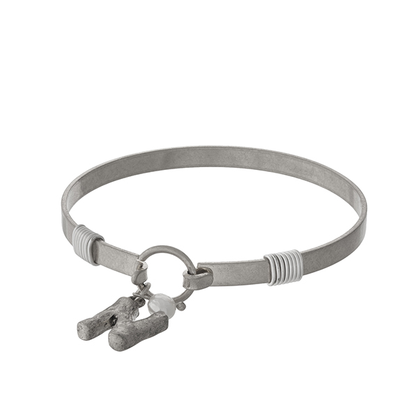 Silver tone bangle bracelet with a hook closure, a block 'N' charm, and a pearl bead accent.