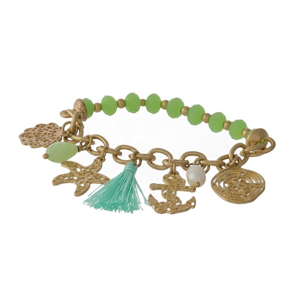 Gold tone and green beaded stretch bracelet displaying sealife and tassel charms. 