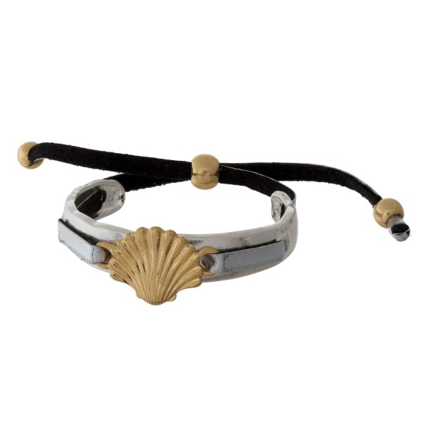 Hammered silver tone bangle bracelet with a gold tone sea life focal and a black cord closure. 
