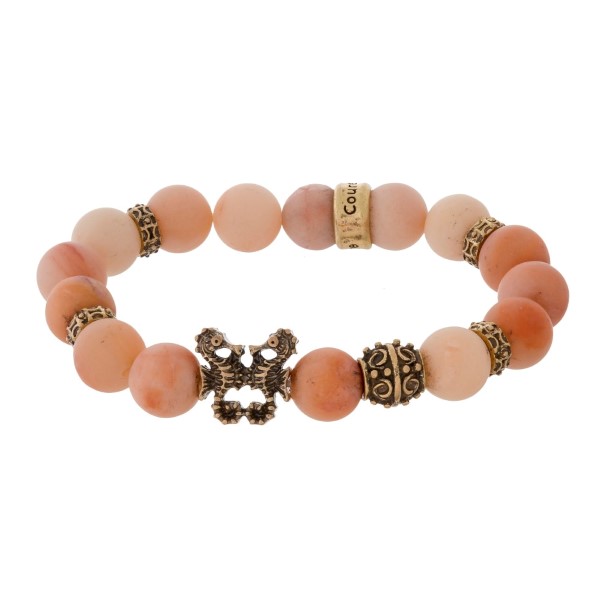 Natural stone beaded stretch bracelet with a gold tone seahorse accent. 