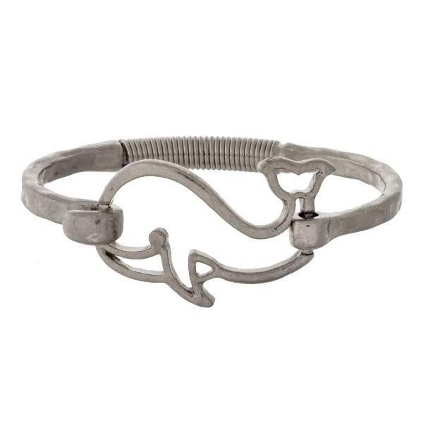 Hammered metal bangle bracelet with a whale focal and a hinge closure. 