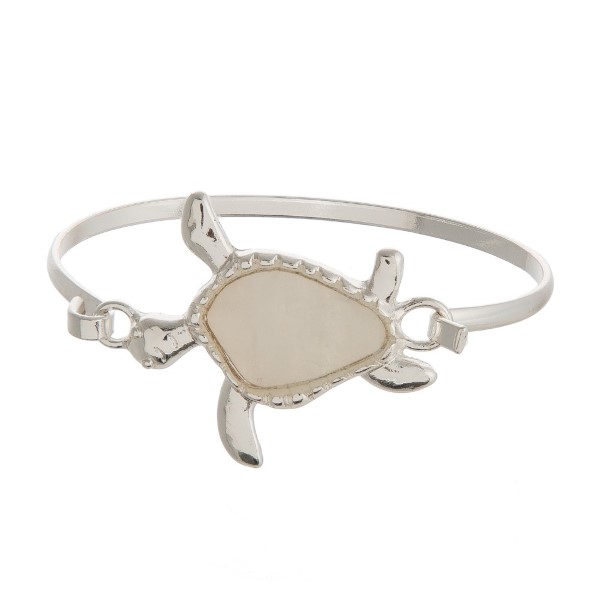 Metal, latch bracelet with a sea life focal accented with natural shell. 