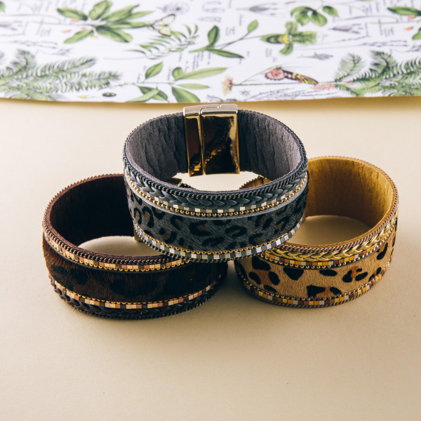 Faux fur leopard print magnetic bracelet featuring braided details. Approximately 3" in diameter and 1" in width. Fits up to a 6" wrist.
