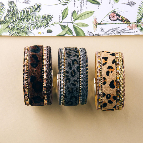 Faux fur leopard print magnetic bracelet featuring braided details. Approximately 3" in diameter and 1" in width. Fits up to a 6" wrist.