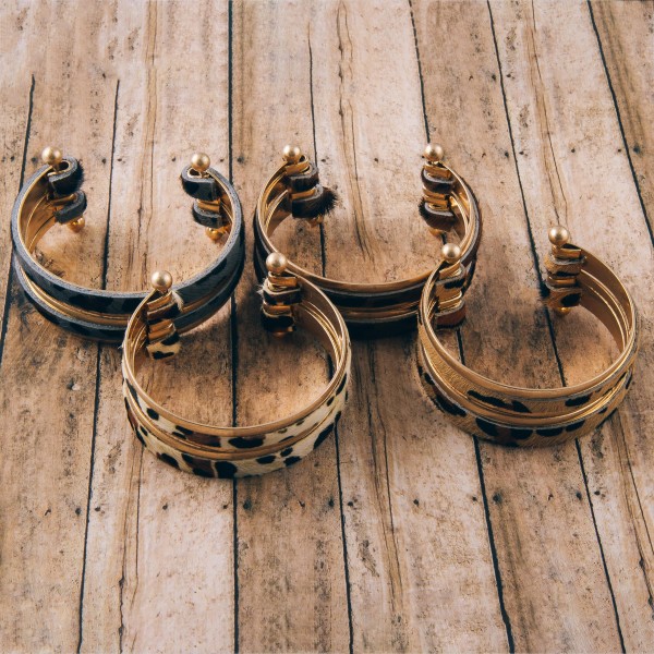 Cowhide leopard print metal bangle cuff bracelet.

- Approximately 2.5" in diameter
- Fits up to a 5" wrist
