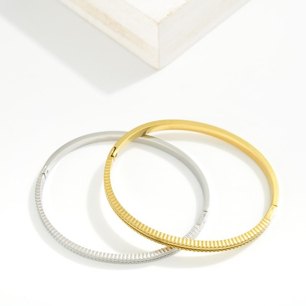 Metal Tone Hinged Bangle Bracelet Featuring Engraved Details 

- Stainless Steel
- Water Resistant
- Approximately 2.5" D