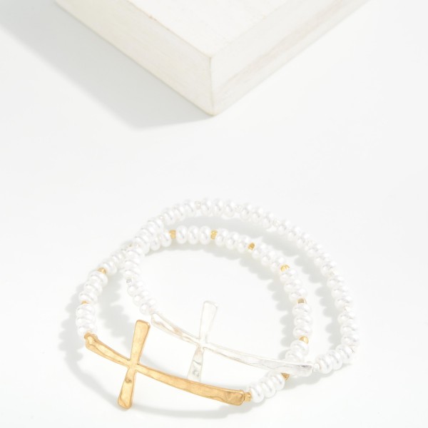 Pearl Beaded Stretch Bracelet Featuring Hammered Metal East West Cross

- Approximately 2.5" D