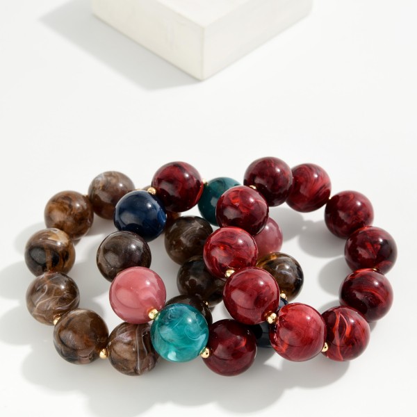 Chunky Resin Bead Stretch Bracelet with oversized marbled beads and tiny metal spacers for a bold, glossy statement. The stretch fit slides right on and stacks easily with bangles and watches. A fun pop for fall sweaters, holiday outfits and weekend looks. Chunky resin bracelets are an easy impulse buy that boutiques sell in multiples.