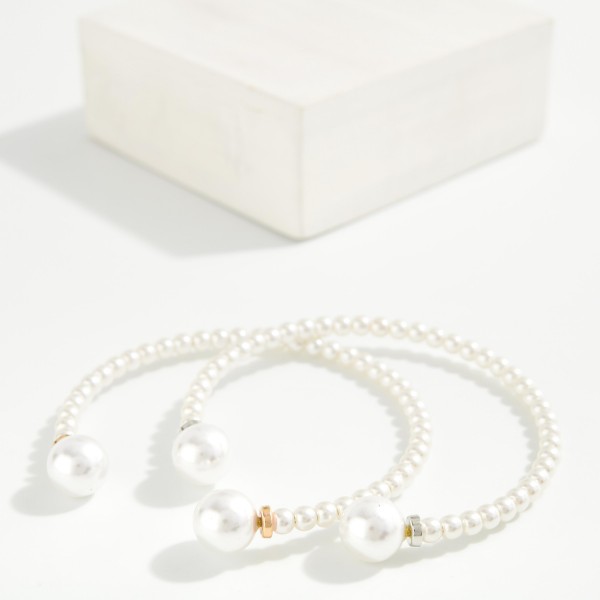 Pearl Bead Cuff Bracelet lined with petite faux pearls and finished with larger pearl ends and polished metal accents. The open cuff design slips on easily and stacks perfectly with chains and bangles. A classic choice for bridal parties, church, the office and everyday polish. Pearl styles are always in demand, and this one makes an easy gift at a friendly price.