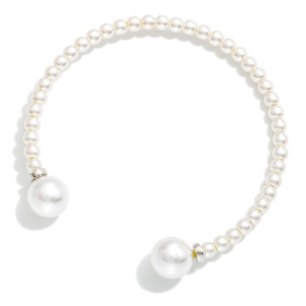 Pearl Bead Cuff Bracelet lined with petite faux pearls and finished with larger pearl ends and polished metal accents. The open cuff design slips on easily and stacks perfectly with chains and bangles. A classic choice for bridal parties, church, the office and everyday polish. Pearl styles are always in demand, and this one makes an easy gift at a friendly price.
