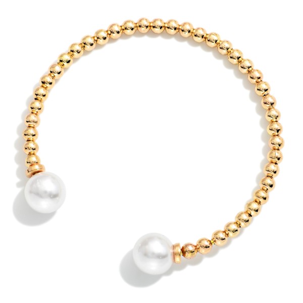 Pearl Tipped Cuff Bracelet with a row of polished metal ball beads finished with a faux pearl at each end. The open cuff slips on easily and adjusts gently for a comfortable fit. Stacks beautifully with bangles and watches or wears alone for a clean, classic look. An easy price point that makes it a natural add on and gift for any age.