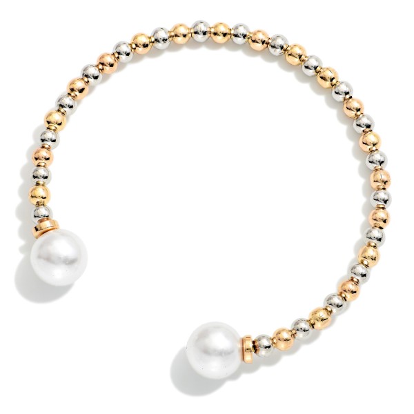 Pearl Tipped Cuff Bracelet with a row of polished metal ball beads finished with a faux pearl at each end. The open cuff slips on easily and adjusts gently for a comfortable fit. Stacks beautifully with bangles and watches or wears alone for a clean, classic look. An easy price point that makes it a natural add on and gift for any age.