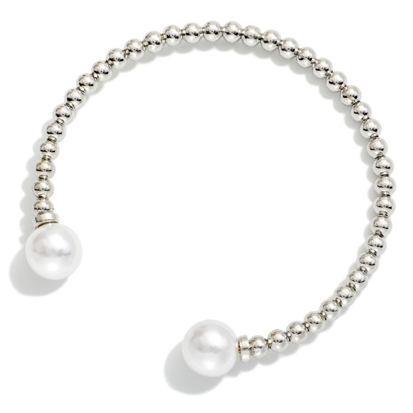 Pearl Tipped Cuff Bracelet with a row of polished metal ball beads finished with a faux pearl at each end. The open cuff slips on easily and adjusts gently for a comfortable fit. Stacks beautifully with bangles and watches or wears alone for a clean, classic look. An easy price point that makes it a natural add on and gift for any age.