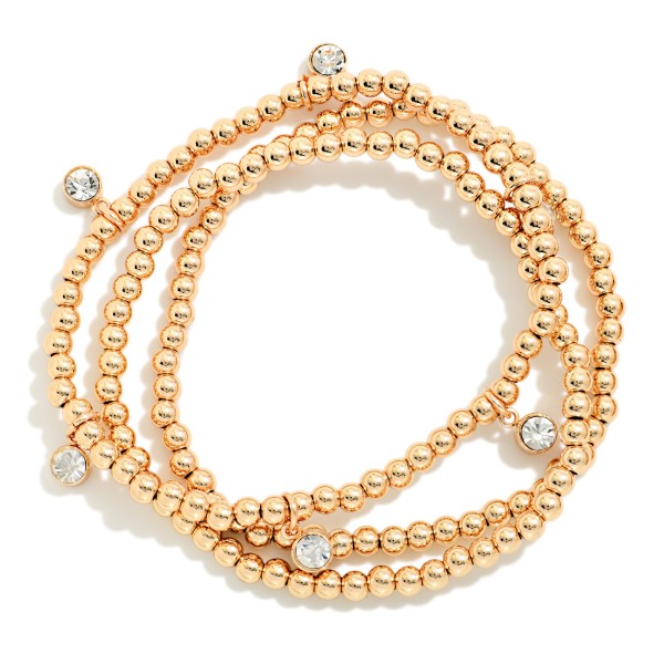 Metal Bead Stretch Bracelet Set featuring strands of polished round beads accented with sparkling bezel set crystals. The stackable strands can be worn together for a full look or mixed into an existing bracelet stack. Comfortable stretch fit with no clasp. A festive, easy gift for the holidays and an everyday stacking staple that appeals to every age.