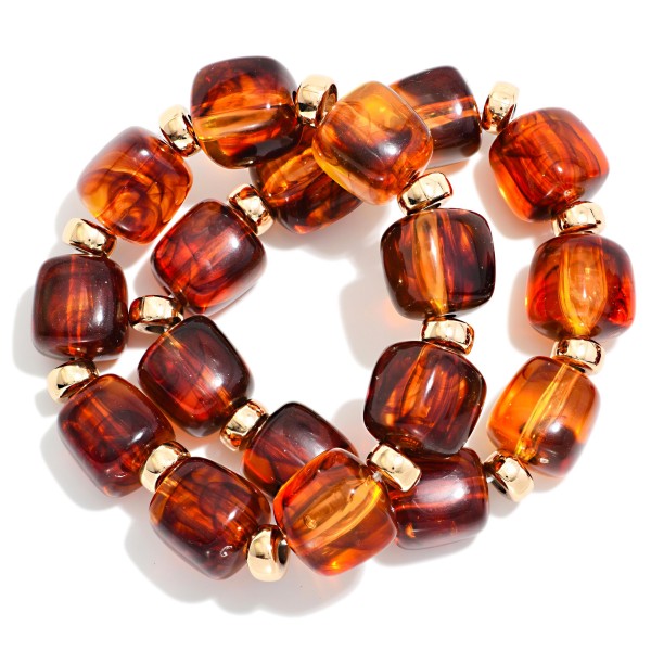 Chunky Marbled Resin Bead Stretch Bracelet featuring oversized cube beads with a swirled, glossy finish separated by polished metal rondelles. The bold beads make a statement on their own or stack easily with bangles and watches. Comfortable stretch fit slides on with no clasp. A trend forward, affordable style that coordinates with fall and holiday wardrobes and sells quickly when displayed in multiples.