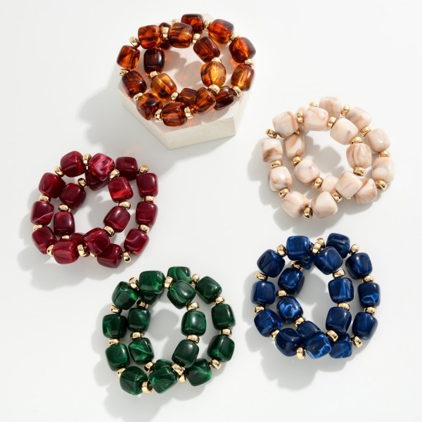 Chunky Marbled Resin Bead Stretch Bracelet featuring oversized cube beads with a swirled, glossy finish separated by polished metal rondelles. The bold beads make a statement on their own or stack easily with bangles and watches. Comfortable stretch fit slides on with no clasp. A trend forward, affordable style that coordinates with fall and holiday wardrobes and sells quickly when displayed in multiples.