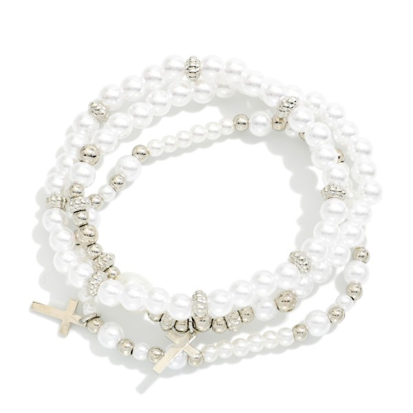 Pearl Cross Charm Stretch Bracelet Set featuring strands of faux pearls accented with sparkling rhinestone rondelles and dangling cross charms. Wear them together for a layered stack or mix with other bracelets for a personalized look. Comfortable stretch fit with no clasp. A beautiful faith gift for baptisms, first communions, Easter, and Mother's Day that sells well year round.
