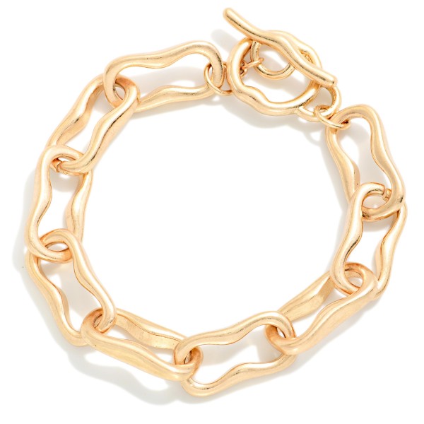 Organic Link Toggle Bracelet featuring wavy, molten style oval links in a soft brushed finish with a front toggle closure. The irregular shapes give it an artisan feel that stands out from classic chains. Easy to fasten and comfortable for all day wear. A modern chain bracelet that stacks well with bangles and pairs with both casual and dressy outfits.