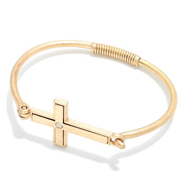 Sideways Cross Wire Bangle Bracelet featuring a polished east west cross centered on a slim wire band with a coiled wrap detail. The hook closure makes it easy to put on and take off. A subtle, meaningful faith piece that stacks beautifully with other bangles. An affordable gift for baptisms, confirmations, and Easter, and a reliable everyday seller.