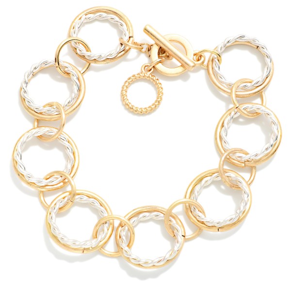 Textured Circle Link Toggle Bracelet made from interlocking round rings with a twisted rope texture and a front toggle closure. The airy, open design feels modern and lightweight on the wrist. Coordinates with the matching circle link necklace for an easy set sale. A polished chain bracelet that layers well with bangles and watches for everyday style.