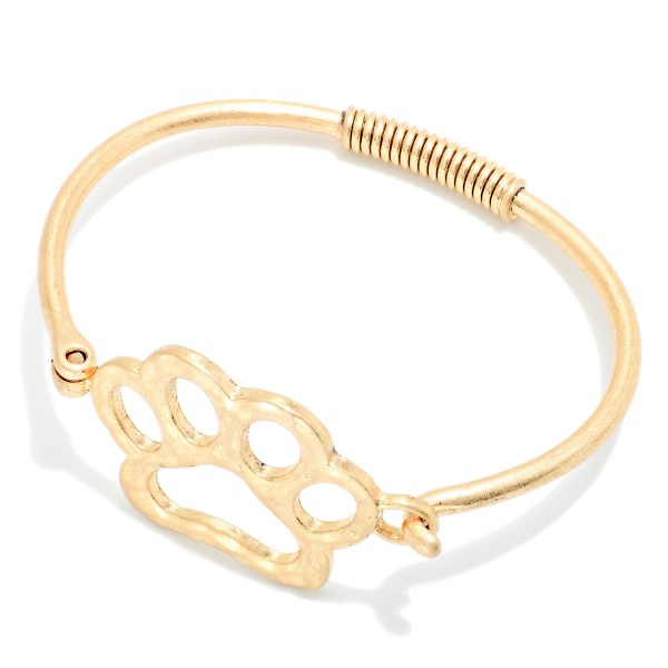 Paw Print Wire Bangle Bracelet featuring an open paw print design set into a slim wire band with a coiled wrap detail. The hook closure makes it easy to put on and take off. A sweet gift for pet lovers, animal rescue supporters, and school spirit fans with a paw mascot. Affordable and easy to stack, it's a fun impulse buy for any boutique.