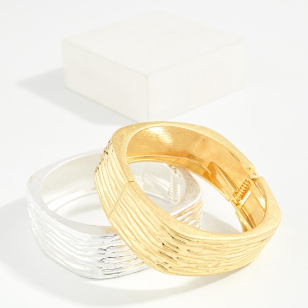 Ridged Square Hinged Bangle Bracelet with a soft cornered shape and a textured ribbed finish. The modern silhouette offers a fresh alternative to classic round bangles. Hinged for easy on and off with a secure closure. A sleek, architectural statement piece that pairs with workwear and weekend outfits alike, perfect for customers looking for something different.